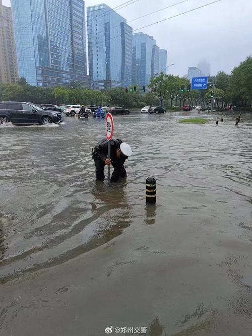 郑州暴雨交警蹚深水抱孩子过马路