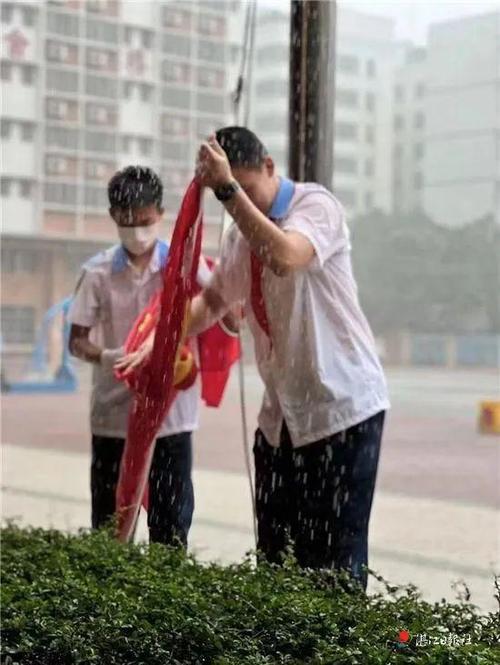 少年暴雨中收起国旗